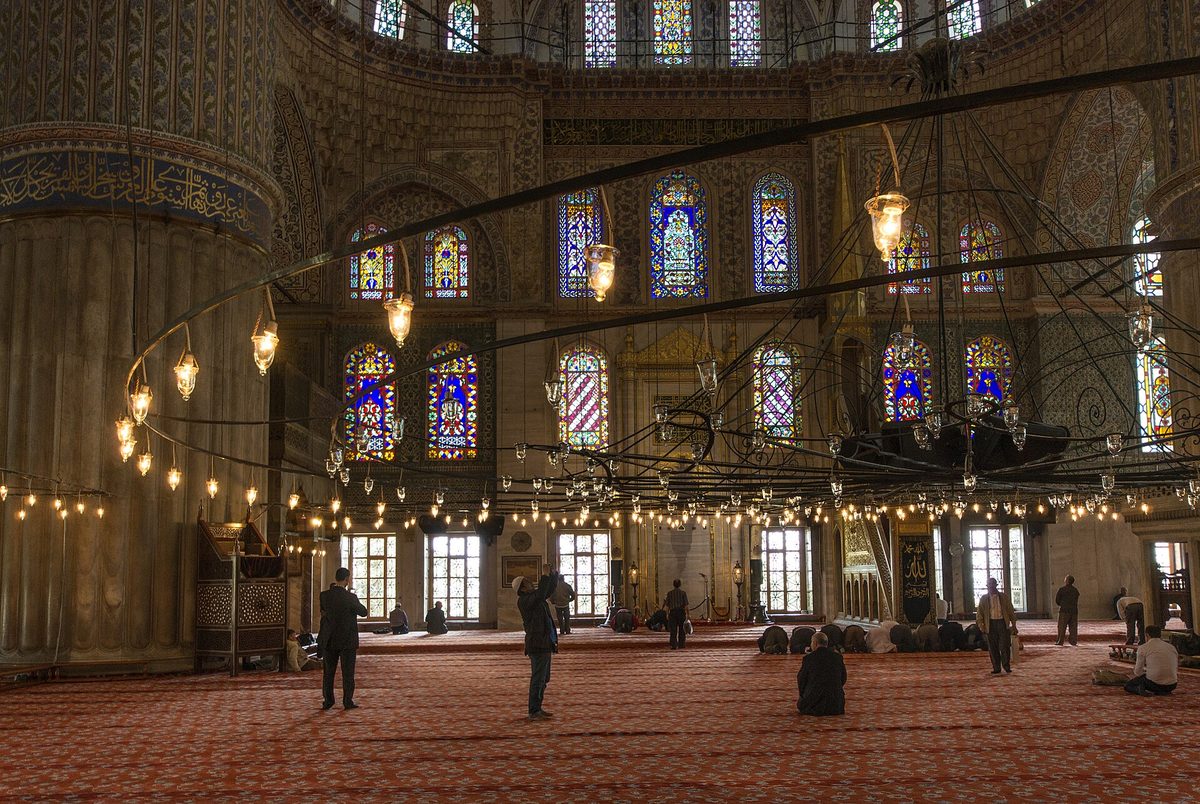 The interior of the Blue Mosque in Istanbul with stained glass windows and patterned tiles