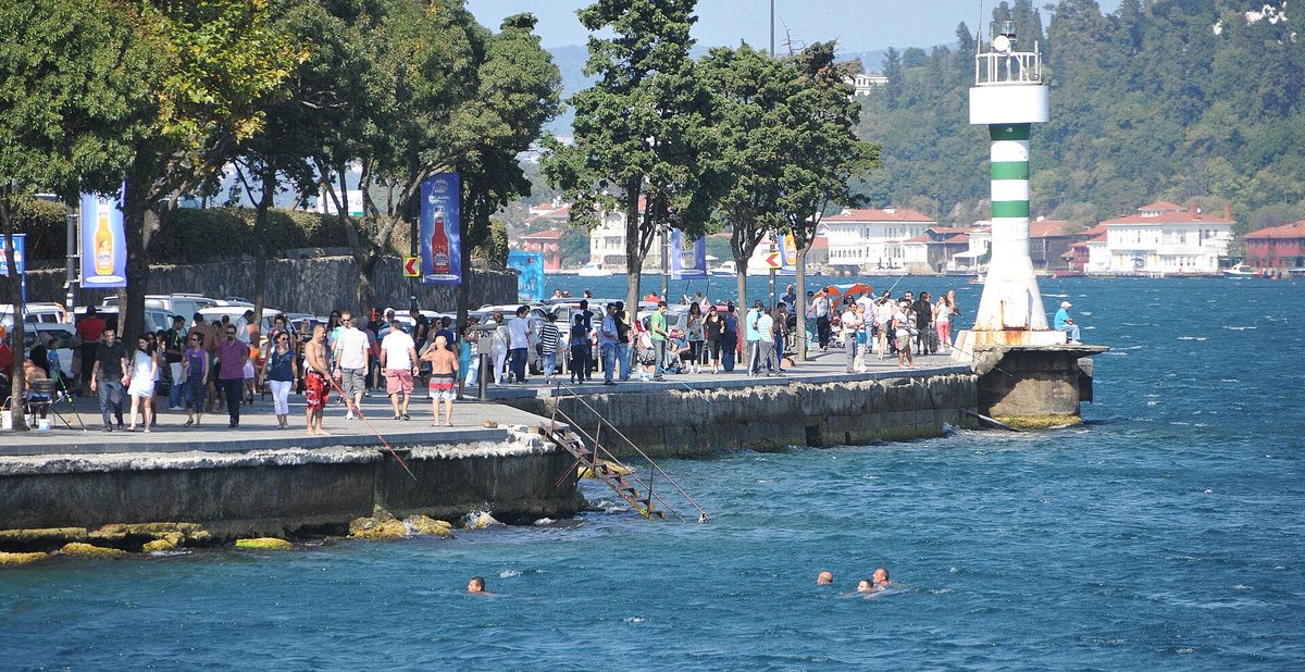 People swimming off a breakwater beside the Bosphorus in Istanbul on a summer afternoon