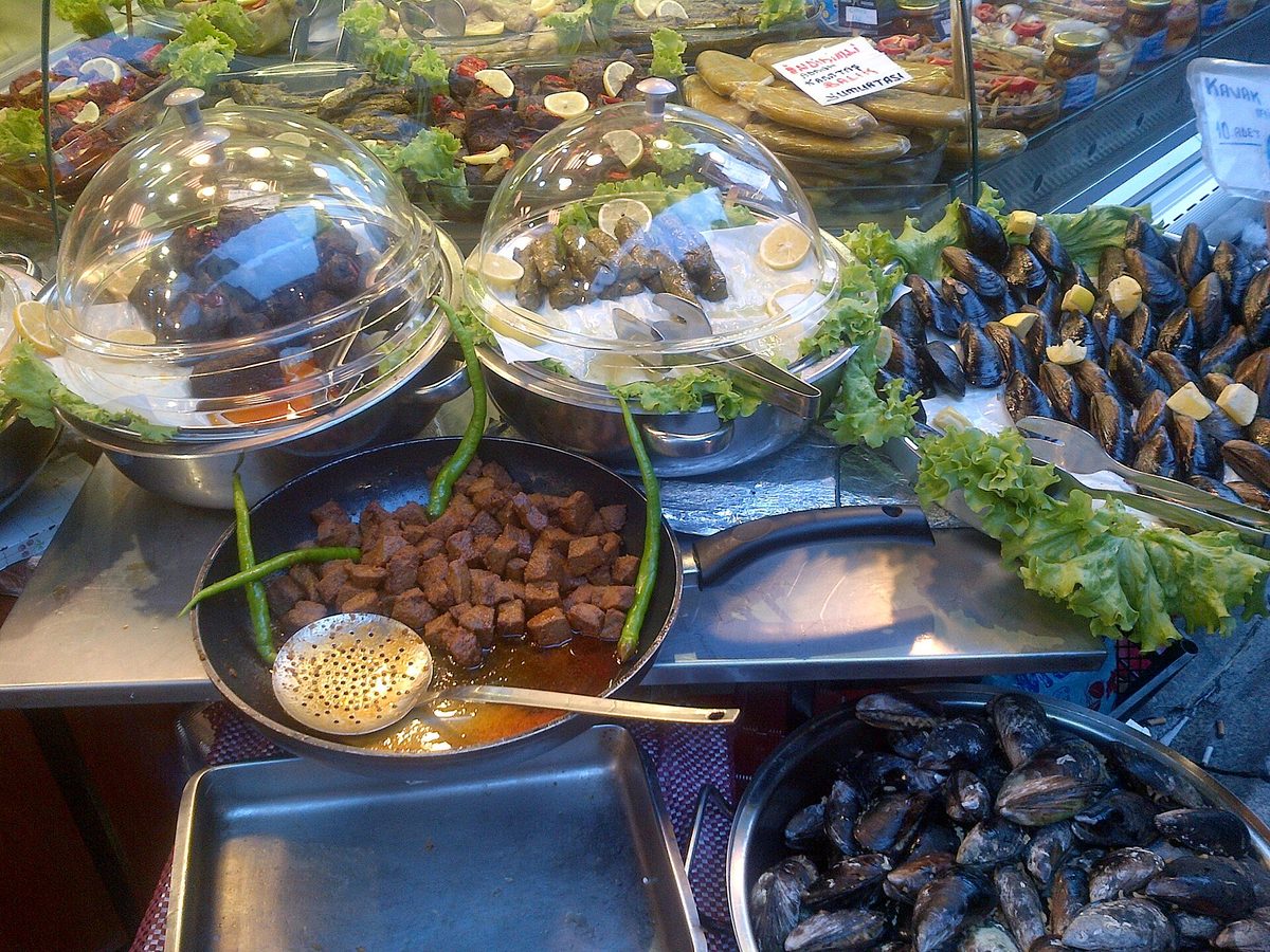 A midye dolma street cart in Istanbul with stuffed mussels arranged on trays