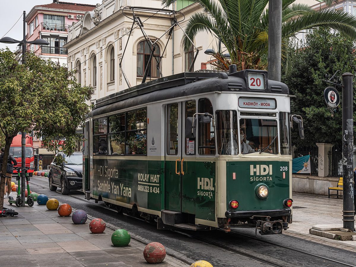 The green nostalgic tram on its route through the tree-lined streets of Moda in Kadikoy