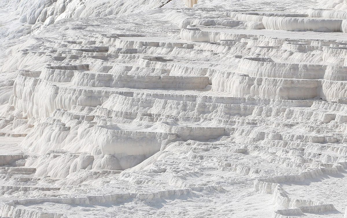 The white travertine terraces of Pamukkale in Turkey, reached by a flight to Denizli beyond Istanbul