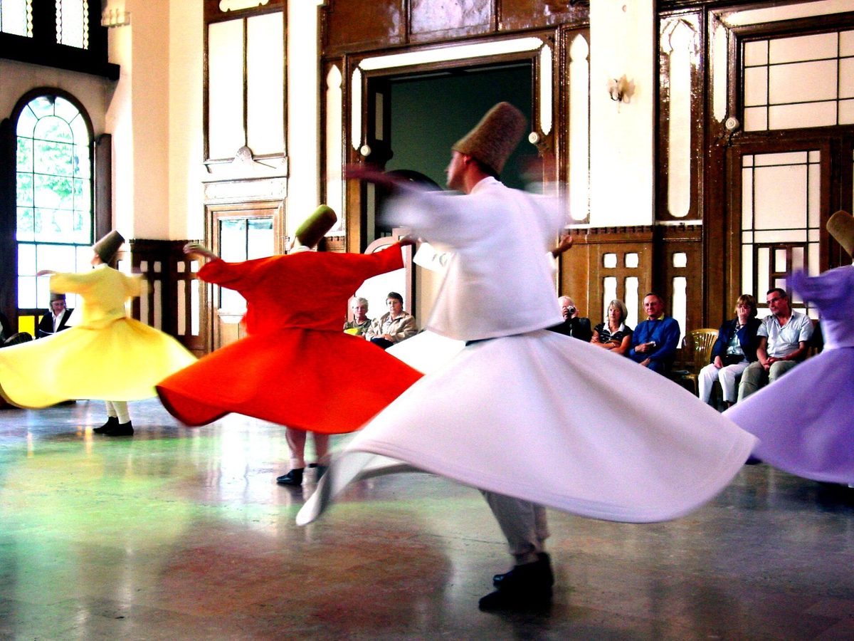 Whirling dervishes in coloured robes and conical hats turning during a sema ceremony in Istanbul