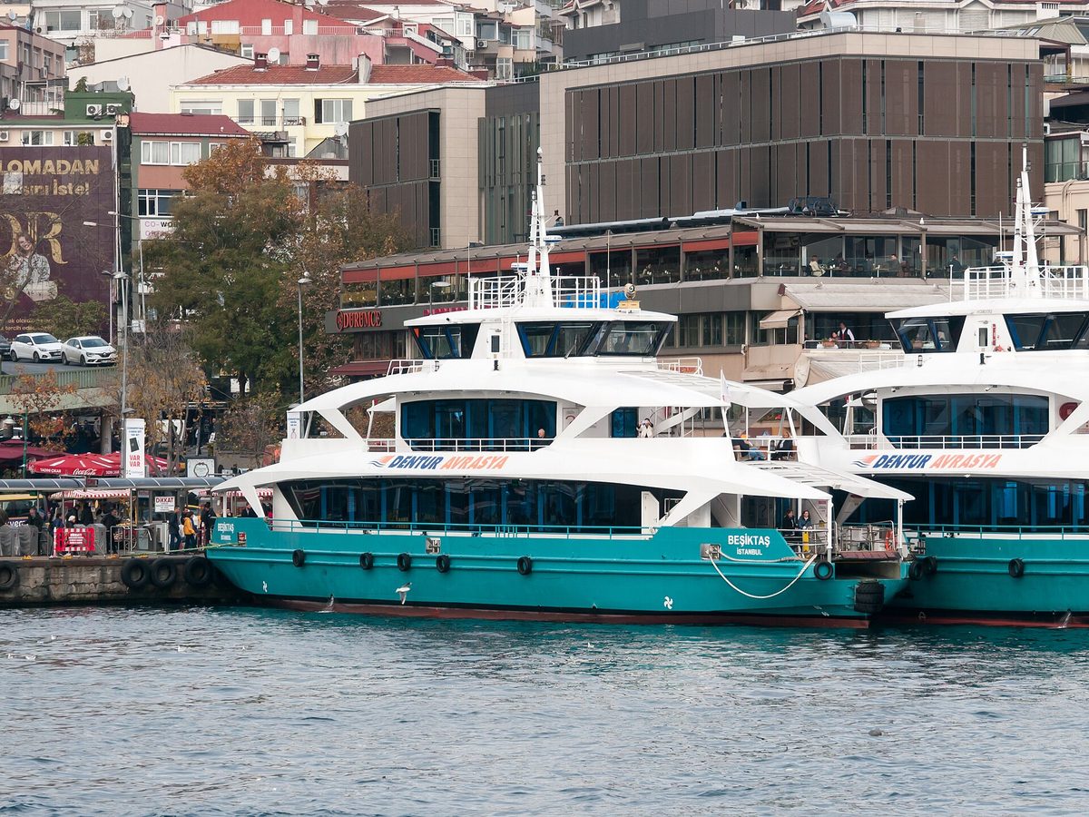 Two turquoise and white Dentur Avrasya passenger boats moored at the Besiktas waterfront